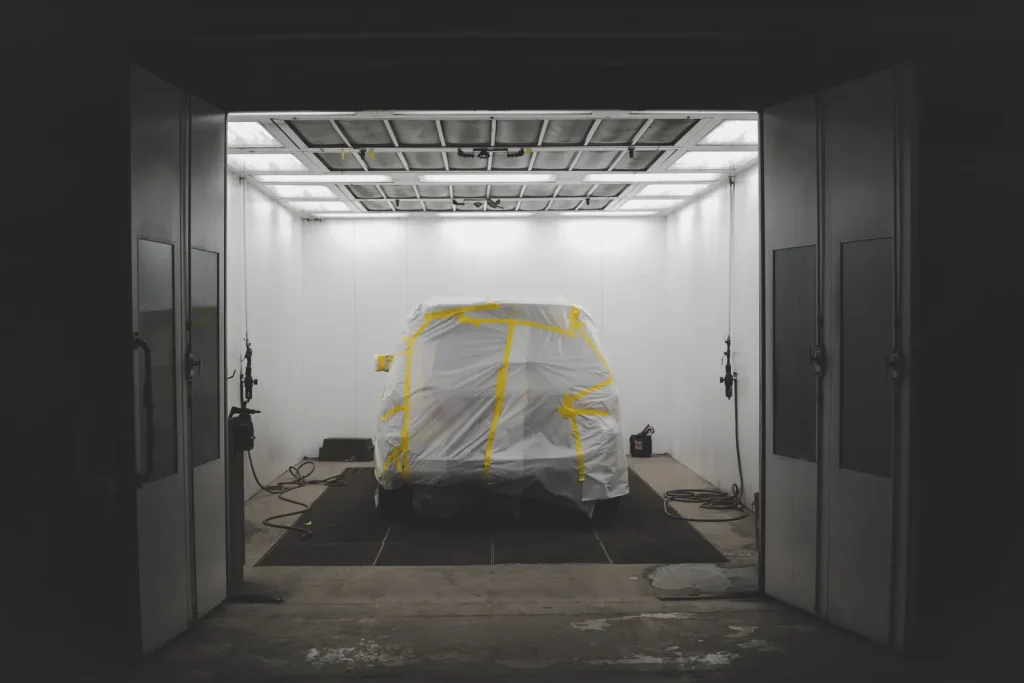 Véhicule masqué dans une chambre à peinture, prêt à peindre
