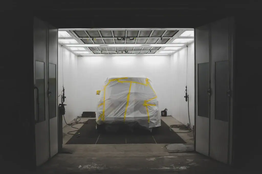 Véhicule masqué dans une chambre à peinture, prêt à peindre