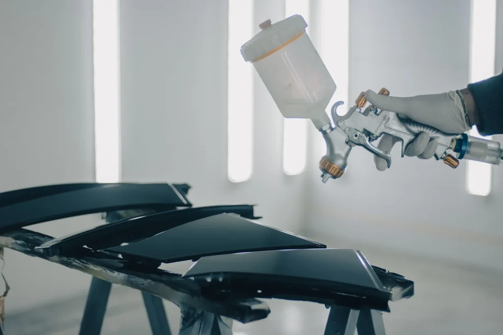 Application de peinture au pistolet sur des pièces de carrosserie